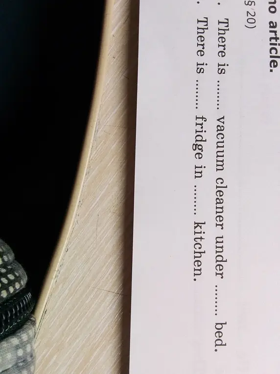 Ты можешь заполнить пропуски в предложениях 'There is ... vacuum cleaner under ... bed' и 'There is ... fridge in ... kitchen'?