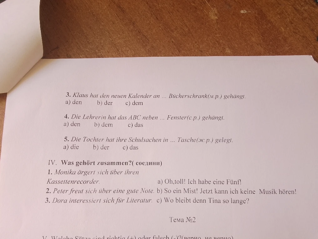Klaus hat den neuen Kalender an ... Bücherschrank(м.р.) gehängt.